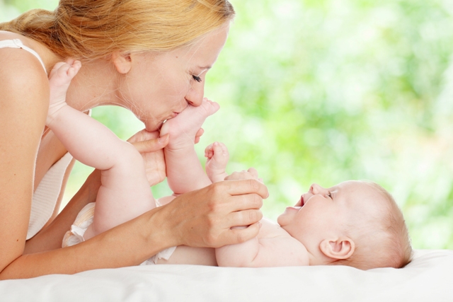 Mother with baby outdoors. Happy family with newborn in summer