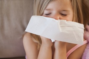 Close-up of a cute little girl suffering from cold